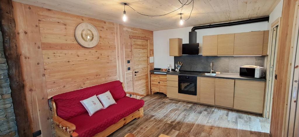 a living room with a red couch in a kitchen at Appartamento Oserot in Bersezio
