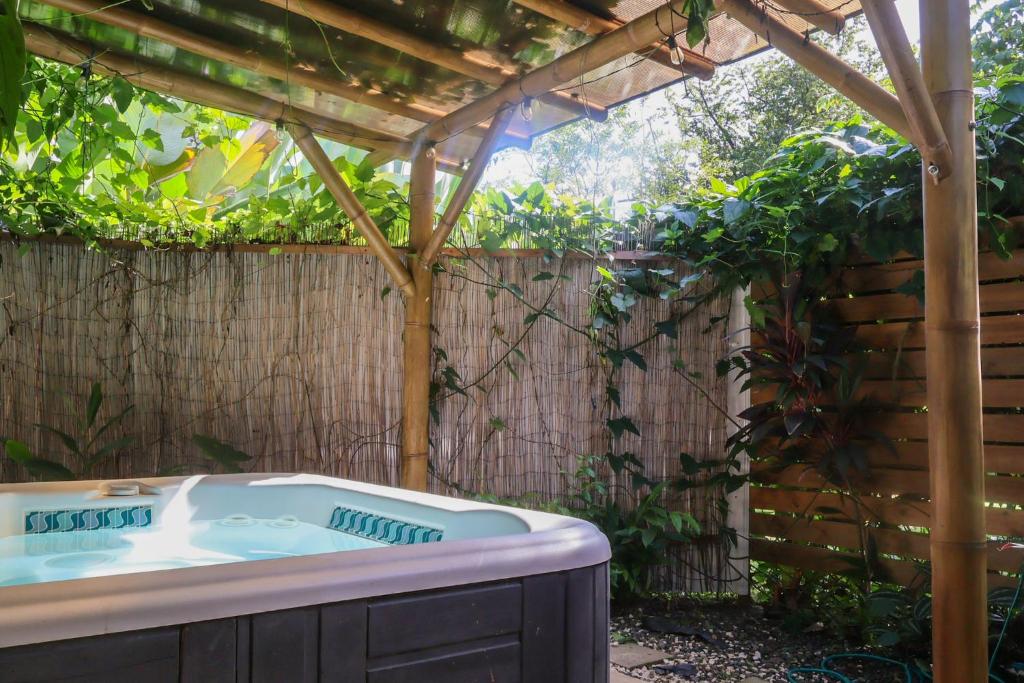 a hot tub in a backyard with a pergola at Colibrí Villa, 800 m from Beach in Uvita