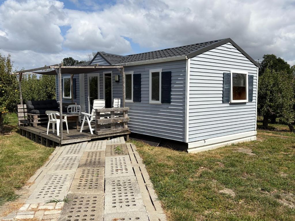 a tiny house with a porch and a deck at Chalet Doyenne in Hengstdijk