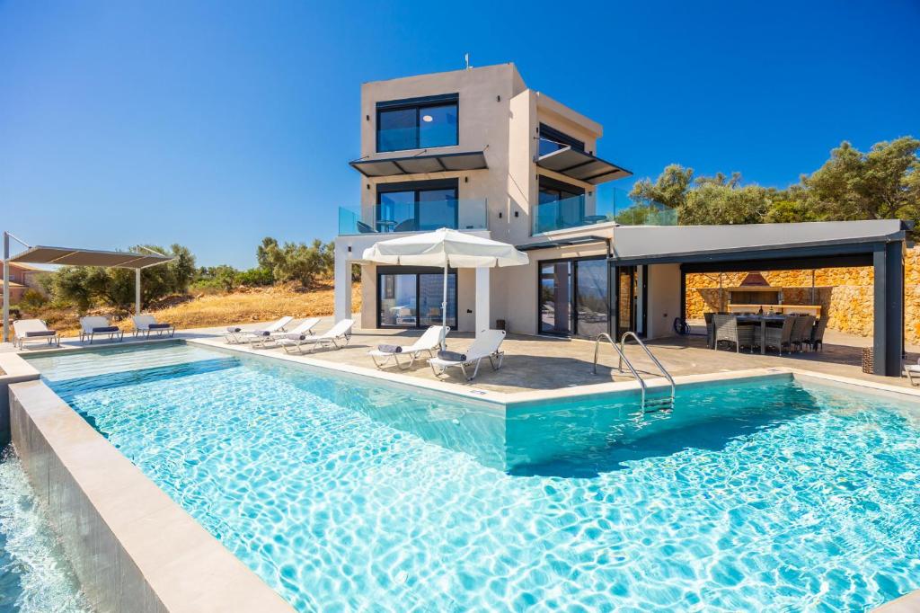 a house with a swimming pool in front of a house at Villa Andria in Apolpaina