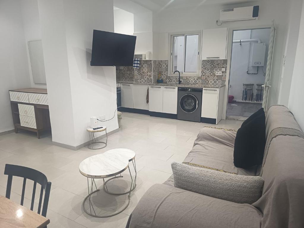 a living room with a couch and a kitchen at Studio en rez-de-chaussée in Hammamet