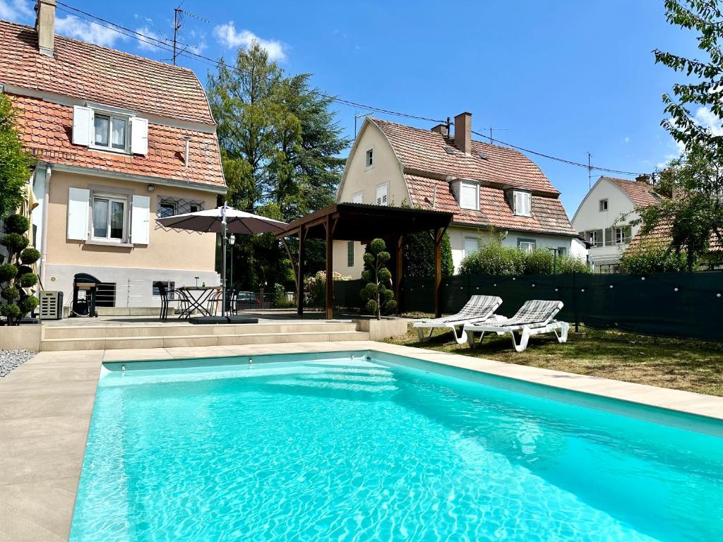 a swimming pool in front of a house at La Parenthèse - Maison avec piscine privée in Wissembourg