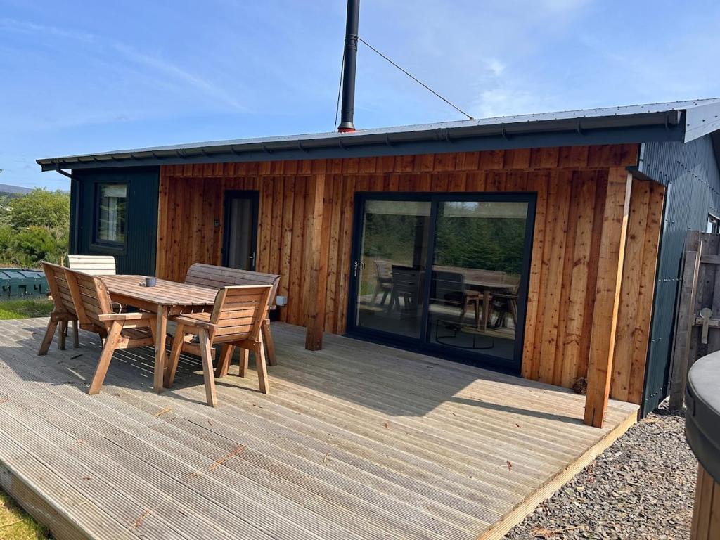 a wooden deck with a table and chairs on a cabin at Sputieburn Bothy in Brora