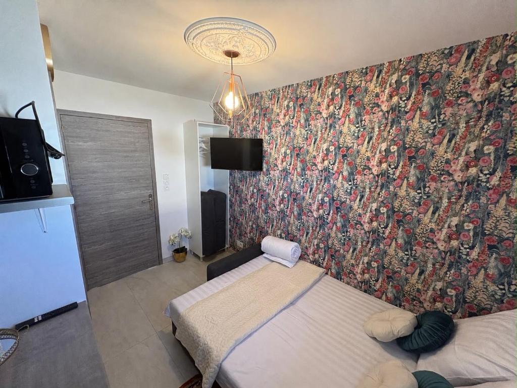 a bedroom with a wall with a floral wallpaper at Prince in Perrigny-lès-Dijon