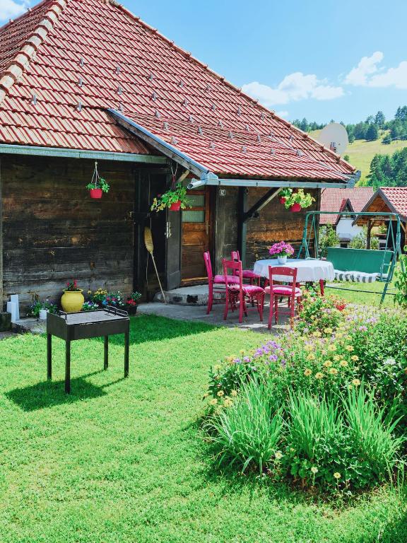 a house with a table and chairs in a yard at Brvnara Zlatni mir in Vodice