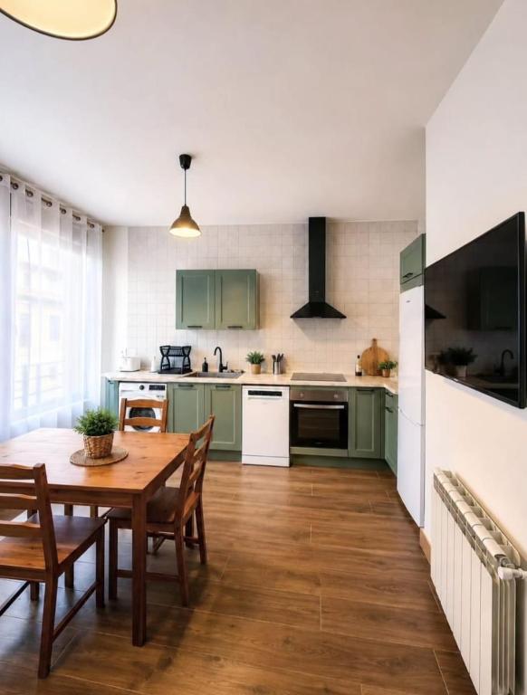 a kitchen with green cabinets and a wooden table at Villa Rural in Cabezuela