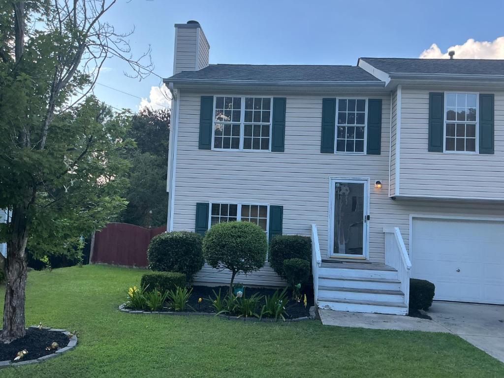 a white house with a door and a yard at Guest Suites in Conley