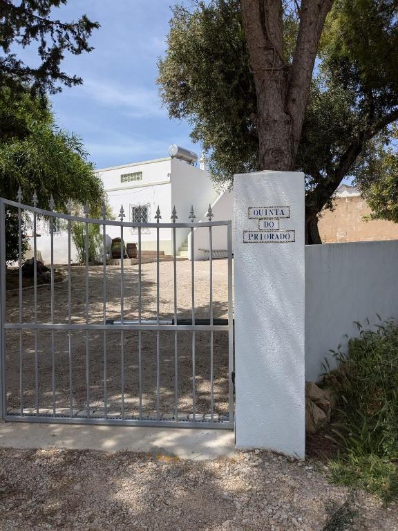 a gate with a sign on it next to a tree at Quinta Do Priorado in Moncarapacho