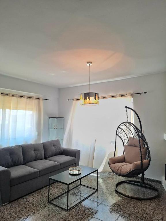 a living room with a couch and a chair at Renas home in Anavyssos