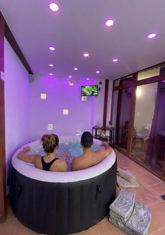 a man and a woman in a hot tub at Flóra apartmanház a Balatonnál in Lovas