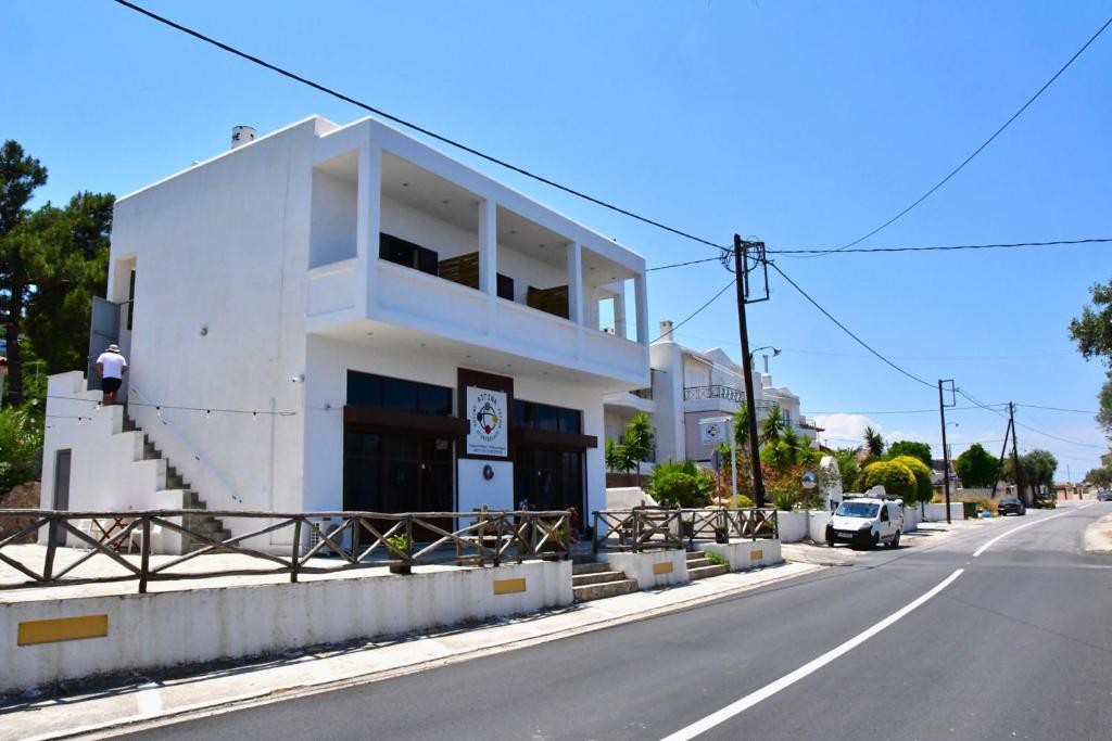 a white building on the side of a street at Sam's Rooms in Vathí