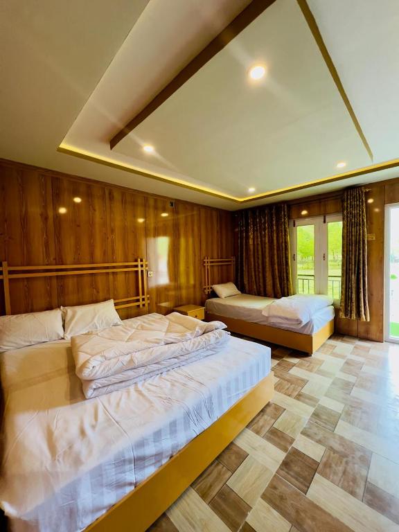 a bedroom with two beds and a large mirror at Saleem Resort in Skardu