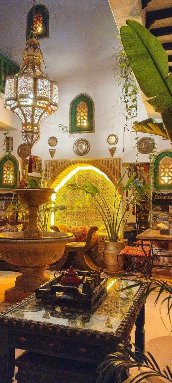 a room with a table with potted plants and lights at riad cherif in Marrakesh