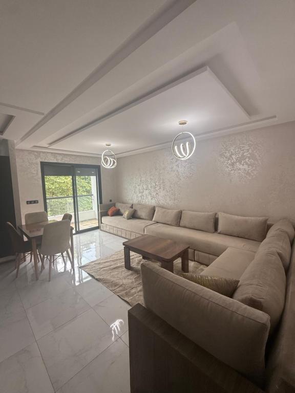 a living room with a couch and a table at Appartement avec balcon vue sur forêt - centre ville in Ifrane