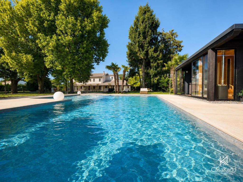 a swimming pool with blue water in front of a house at CasaKadd Grand Escape in Civé