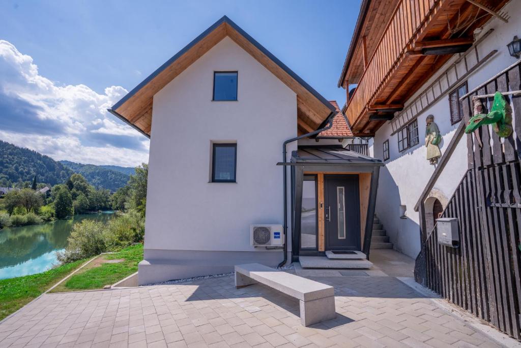 a building with a bench next to a river at Sten House in Škofja Loka