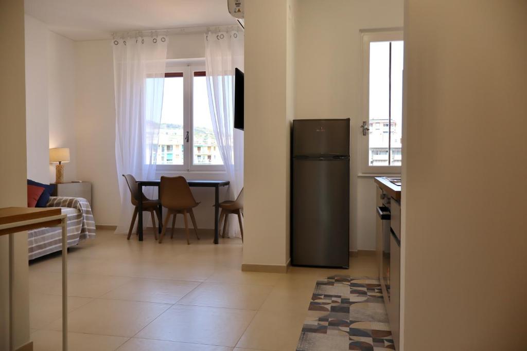 a kitchen with a refrigerator and a table with chairs at Casa Riviera Chiara con Parcheggio Privato nel Cuore di Arma in Arma di Taggia