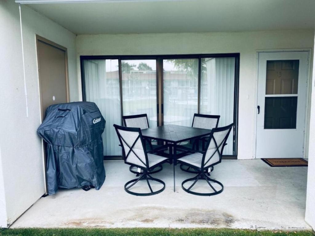 a black table and chairs on a patio with glass doors at #13 Condo near large pool-Gorge shuttle-book separately in Quincy