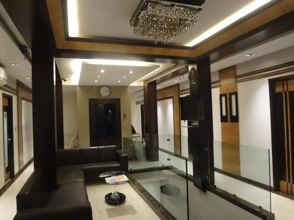 a living room with a couch and a mirror at Hotel Causeway, Colaba in Mumbai