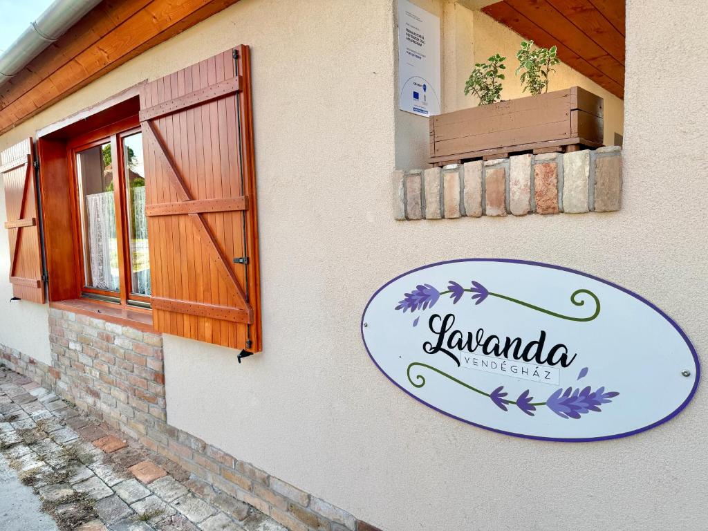 a sign on the side of a building with a door at Lavanda Vendégház in Németkér