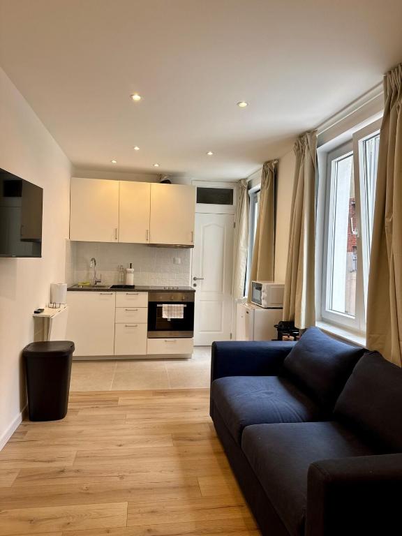 a living room with a couch and a kitchen at Le Cocon in Brussels