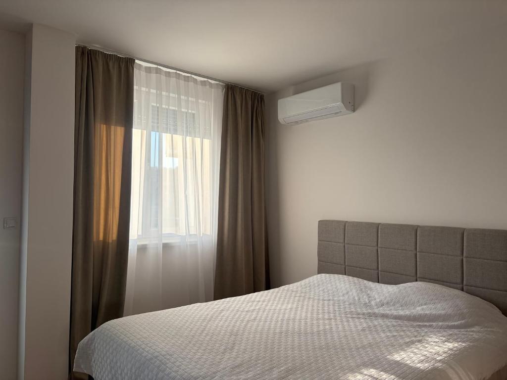 a bedroom with a bed and a window at Apartman S52 City Centre in Doboj