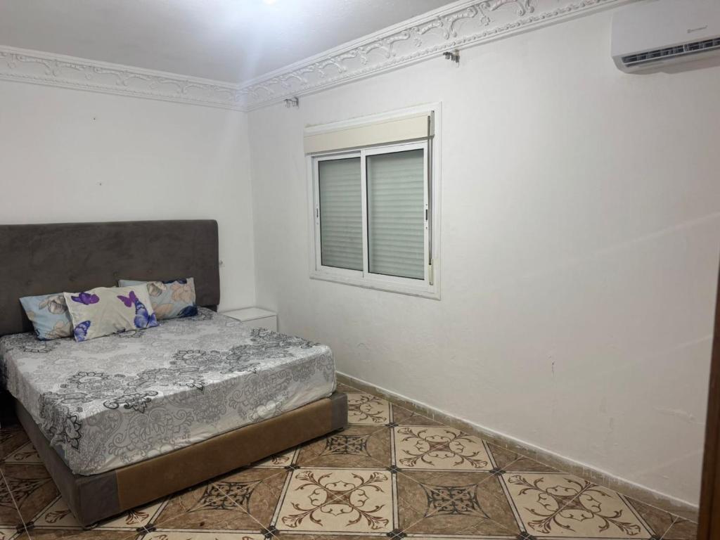a bedroom with a bed and a window at Ahmed sarii in Asilah