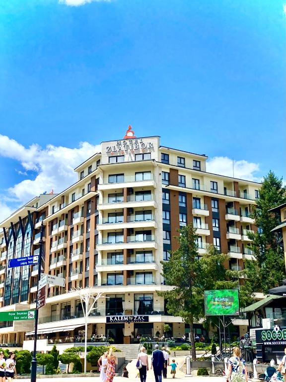 a large building with a sign on top of it at Pine Residence Zlatibor in Zlatibor