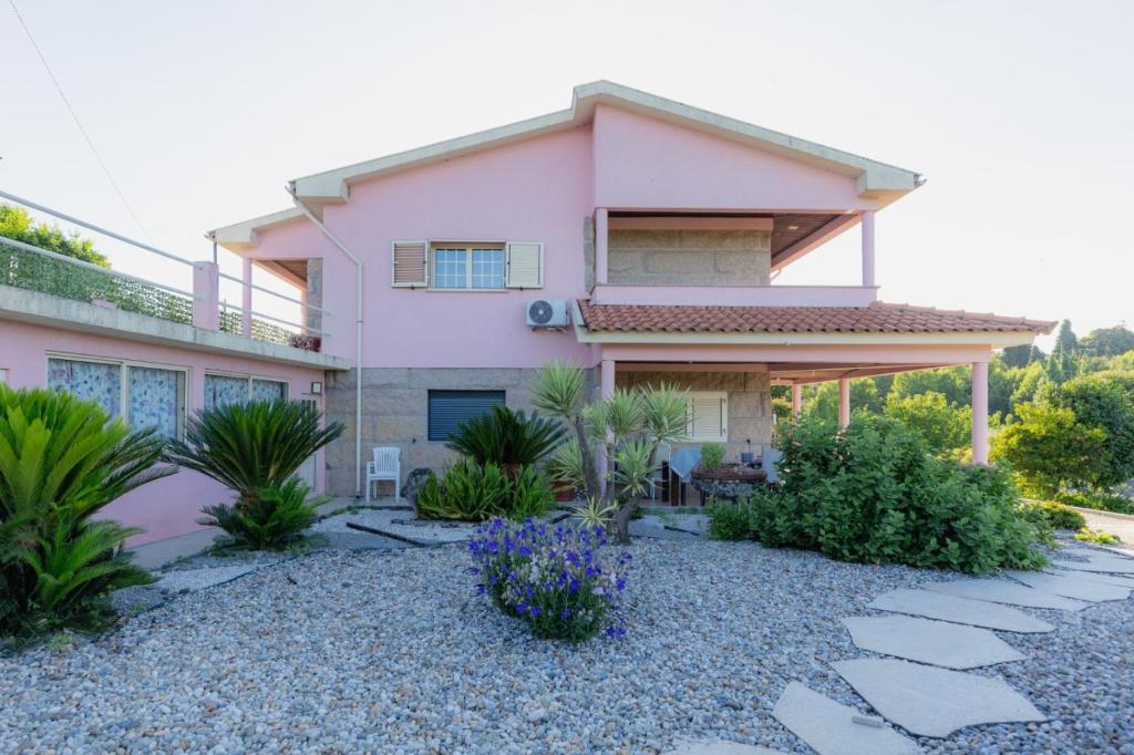 a pink house with plants in front of it at Casa da Cesta in Celorico de Basto
