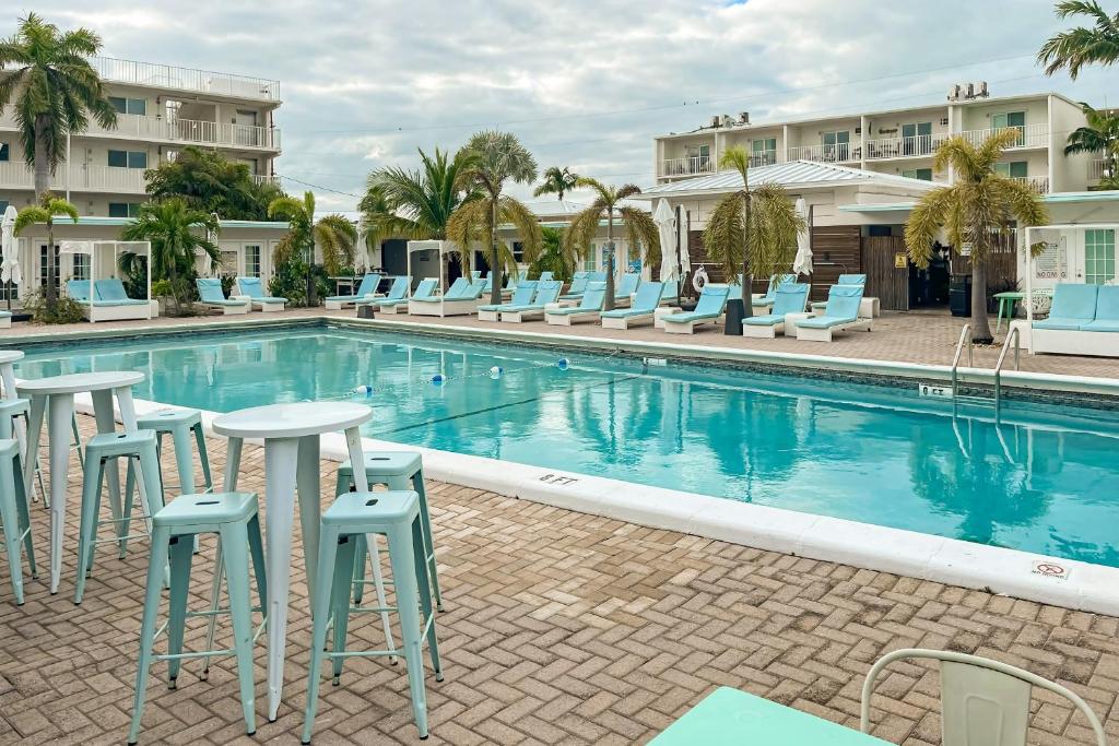 a pool with chairs and tables next to a hotel at MA221 The Tropical Cove 329 in Marathon