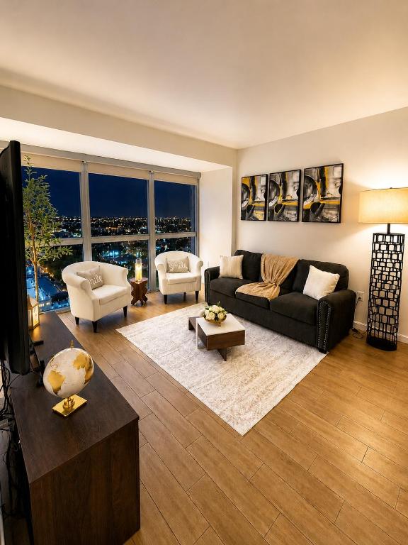 a living room with a black couch and a table at Luxury Skyline Apartment- Resort-Style Pool , Gym & Game Room in Fort Myers