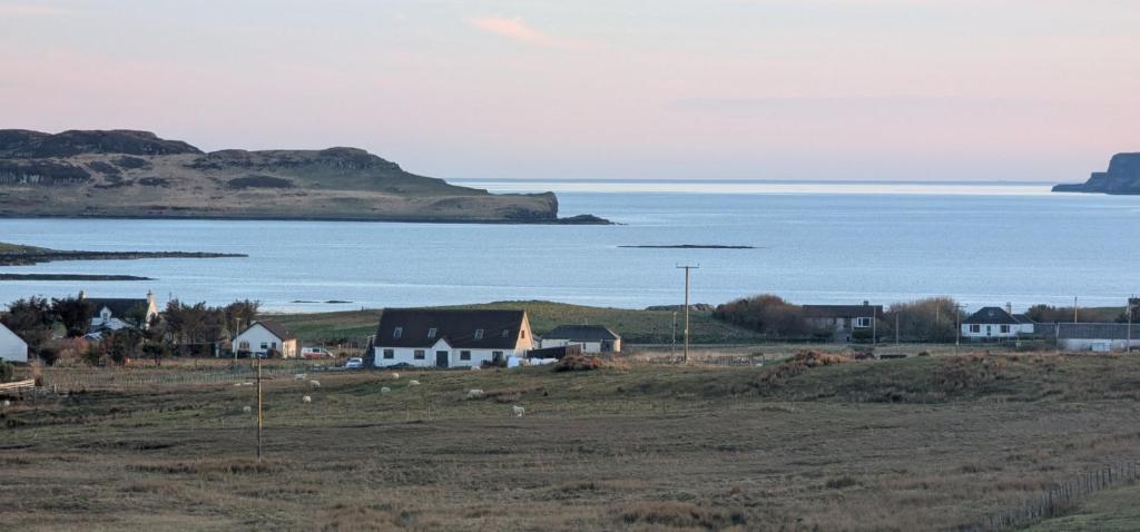 a group of houses in a field next to the ocean at Achalochan House in Ose