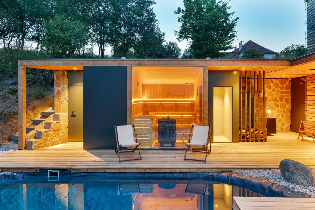 a house with a pool and two chairs on a deck at Sauna House Zelené Údolí in Rabyně