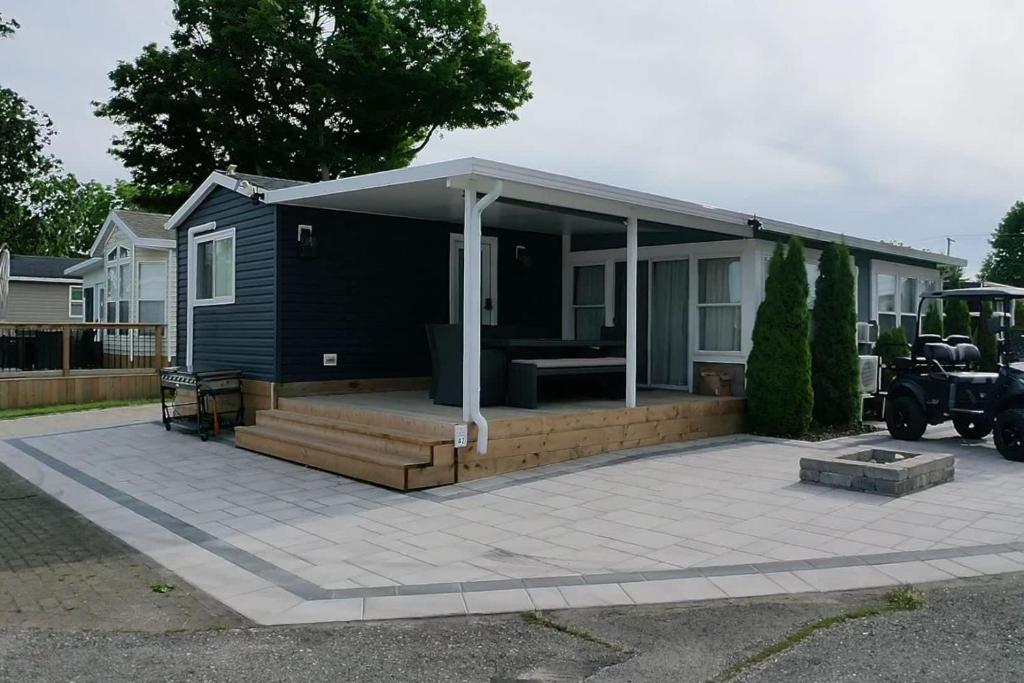 a small house with a patio with a roof at Sherkston Shores Cottage in Port Colborne
