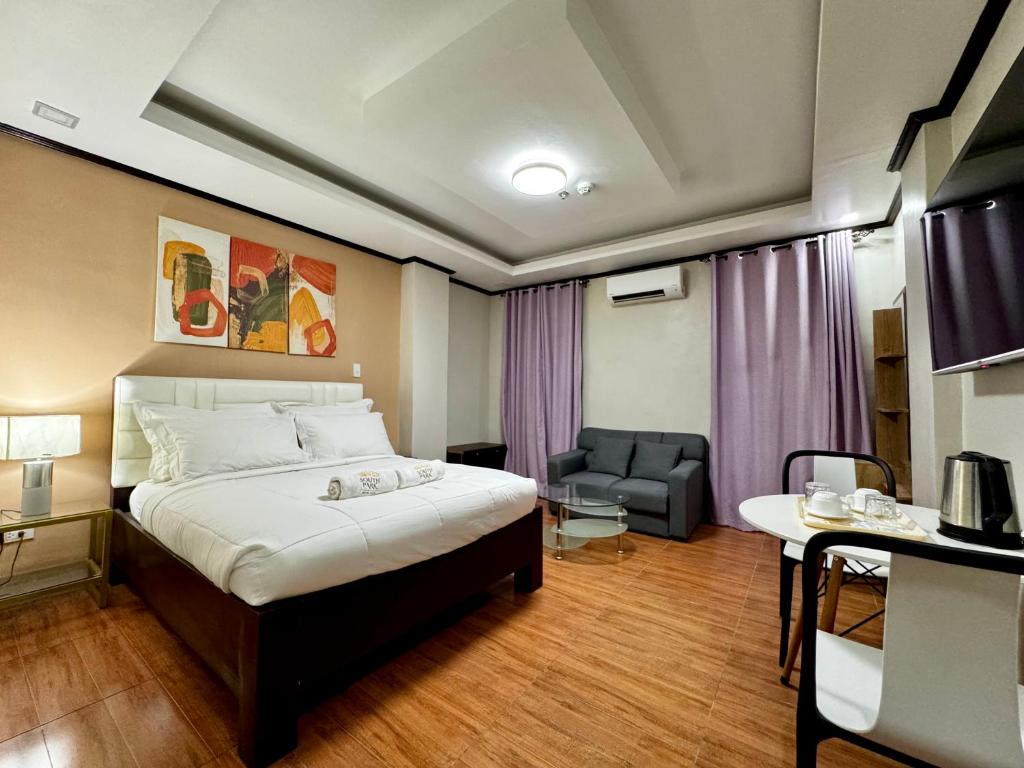 ein Hotelzimmer mit einem Bett und einem Stuhl in der Unterkunft SouthPark Hotel Naga in Concepcion