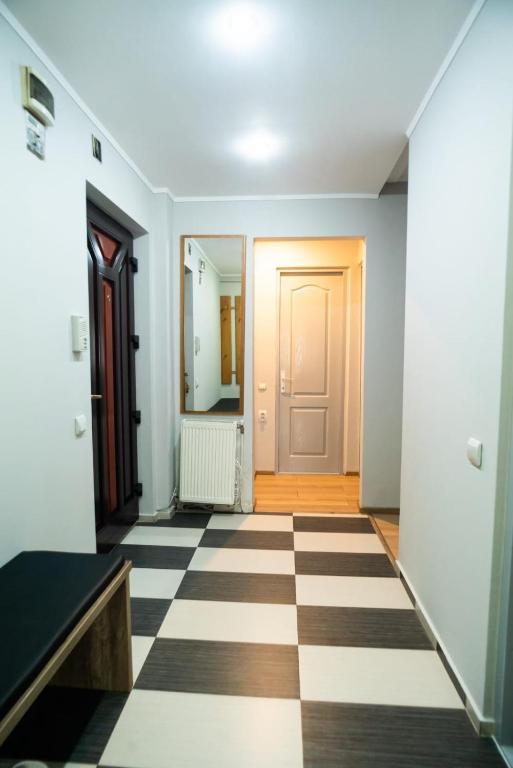 an empty hallway with a door and a checkered floor at Elite Apartament Hunedoara in Hunedoara