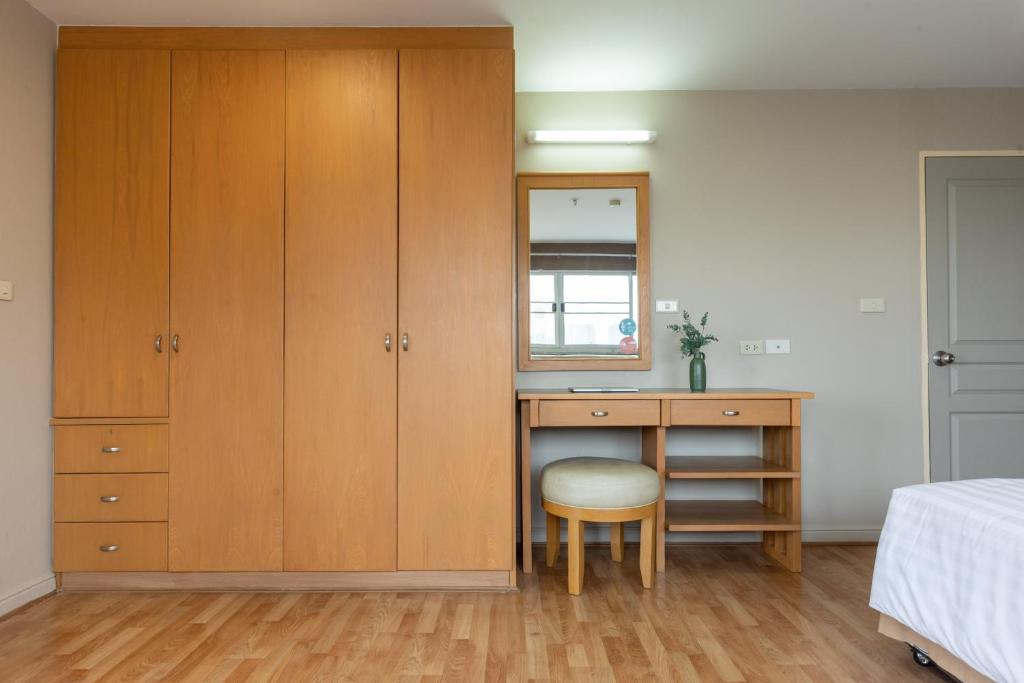A bedroom-side dressing and work area with a full-height wardrobe and mirror.