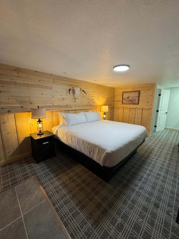 a bedroom with a large bed with wooden walls at Suite 102 in Lusk