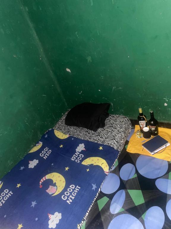 a bed in a room with a green wall at Least desirable room in Rwamagana