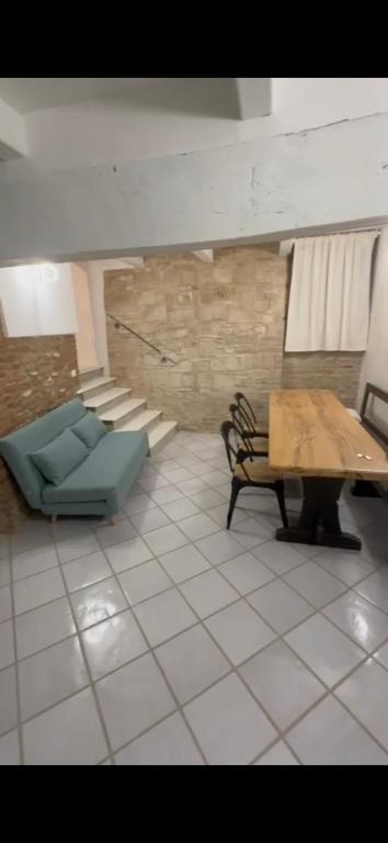 ein Zimmer mit einem Tisch und einer Couch sowie einem Tisch und Stühlen in der Unterkunft Il Nido delle Marche in Sarnano