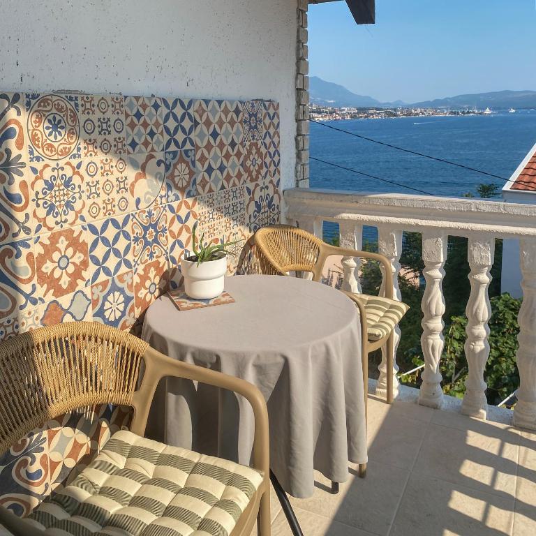 a table and chairs on a balcony with a view of the water at Saint Sunday in Kamenari