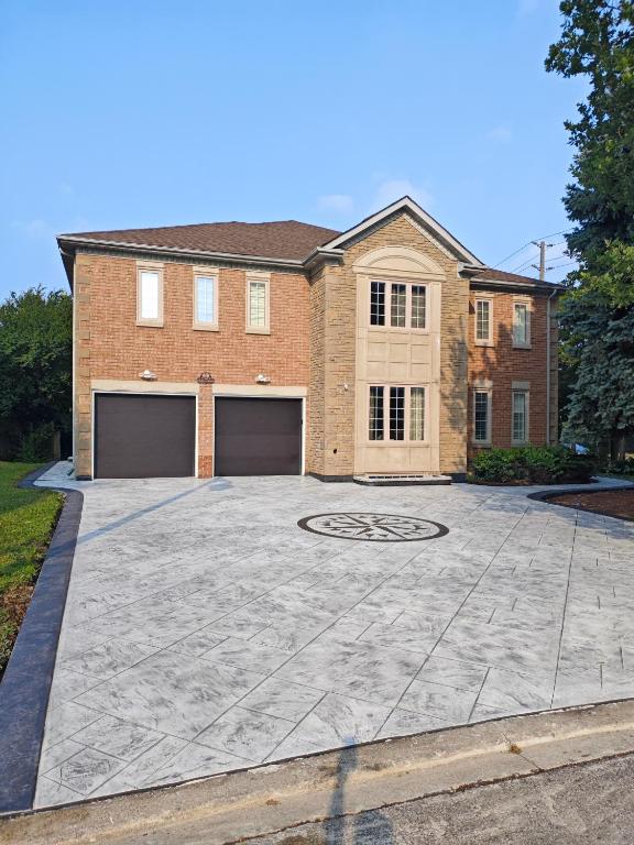 a house with a large driveway in front of it at New and Stylish 3BR Private Basement Apartment with 3 Baths & Parking in Richmond Hill