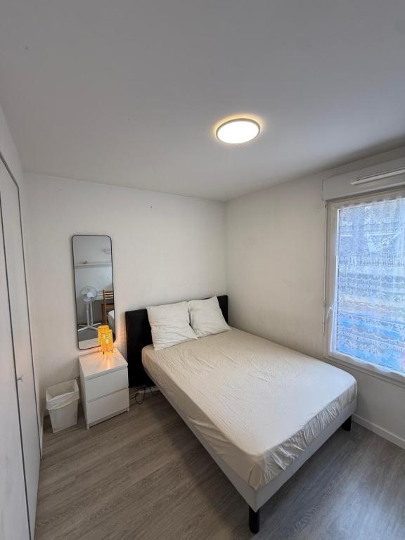 a small bedroom with a bed and a mirror at Une petite chambre cosy in Dijon