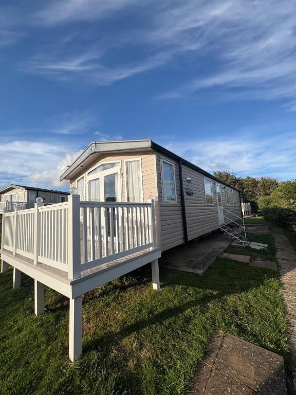 a mobile home with a porch and a deck at Sandytoes and Seaside smiles in Wyke Regis