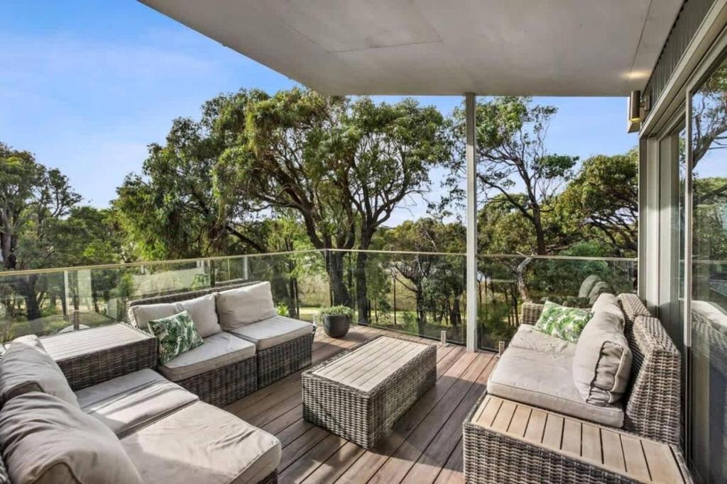 a patio with couches and chairs on a deck at Coastal Tree Top Views in Aireys Inlet