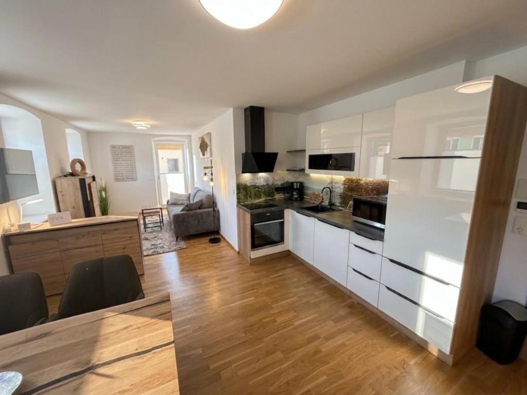 a kitchen and living room with white cabinets and wooden floors at Murleben Top 05 in Stadl an der Mur