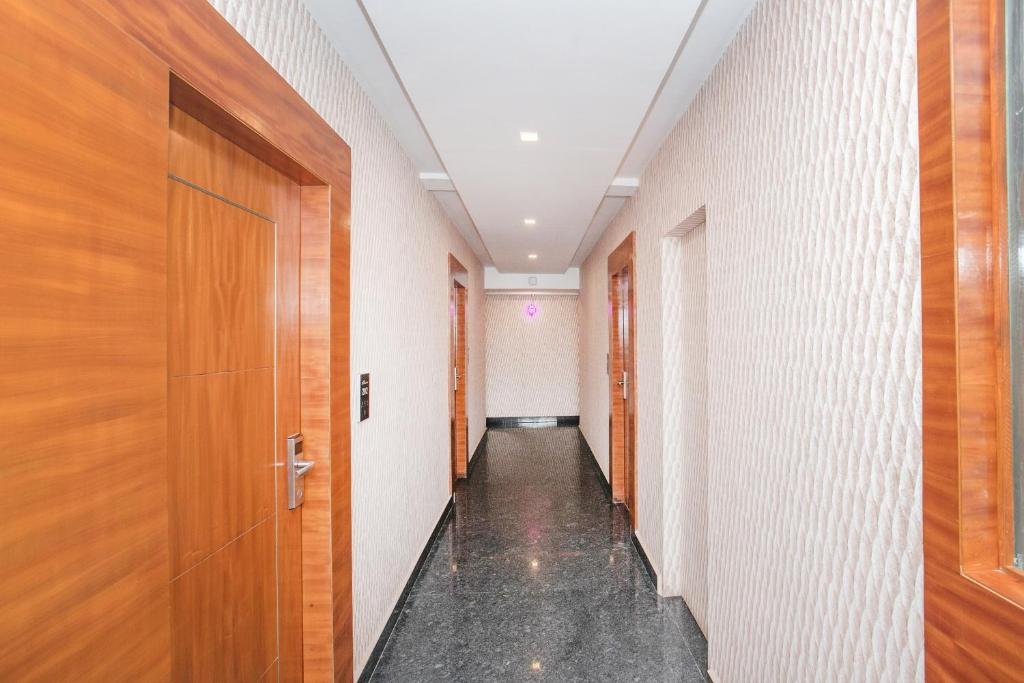 a corridor of a hallway with wooden doors at Hotel O Royal Stay in Bangalore
