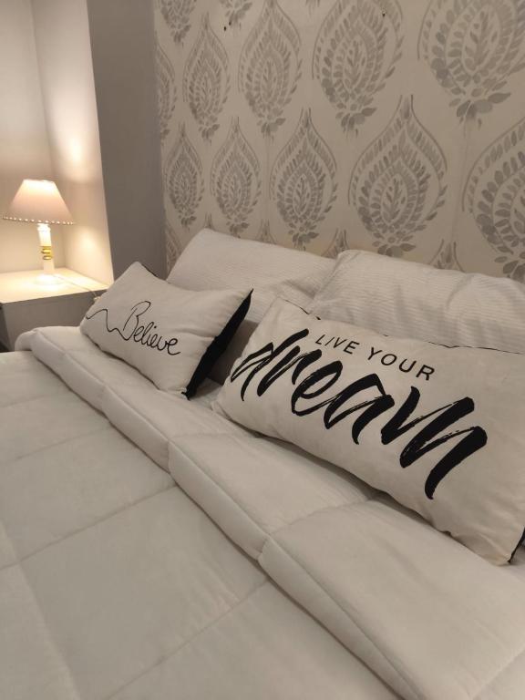 a white bed with two pillows on top of it at Dpto Plaza Colon in Azul