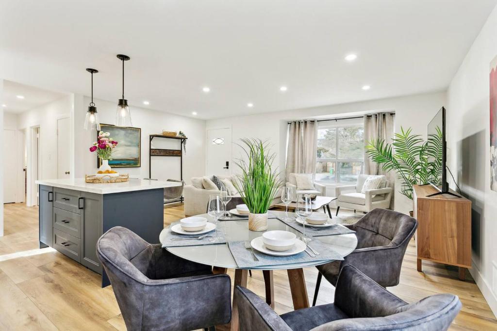 a dining room and living room with a table and chairs at Modern 3BR Home, Minutes to Lake & Port Credit in Mississauga