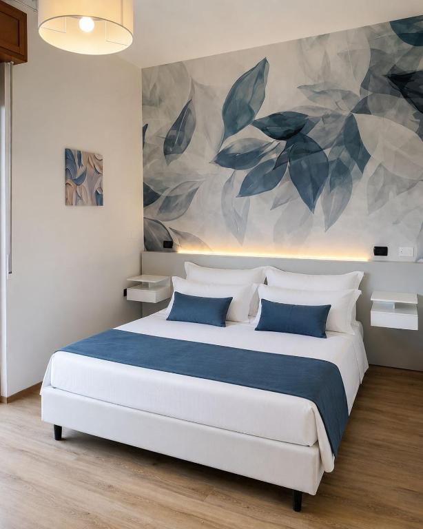 a bedroom with a large bed with a painting on the wall at Hotel IL MULINO - Colazione a Buffet e Parcheggio Privato in Casalgrande